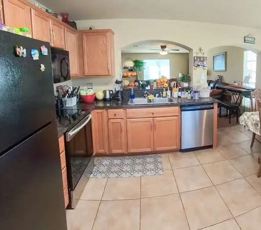 a kitchen with stainless steel appliances granite countertop a refrigerator and a stove