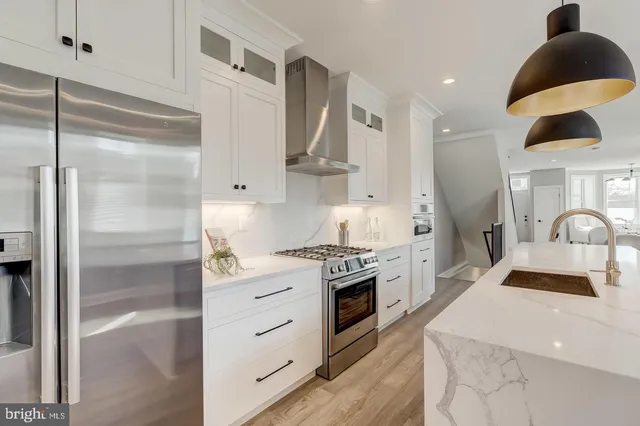 a kitchen with stainless steel appliances granite countertop a sink stove and refrigerator