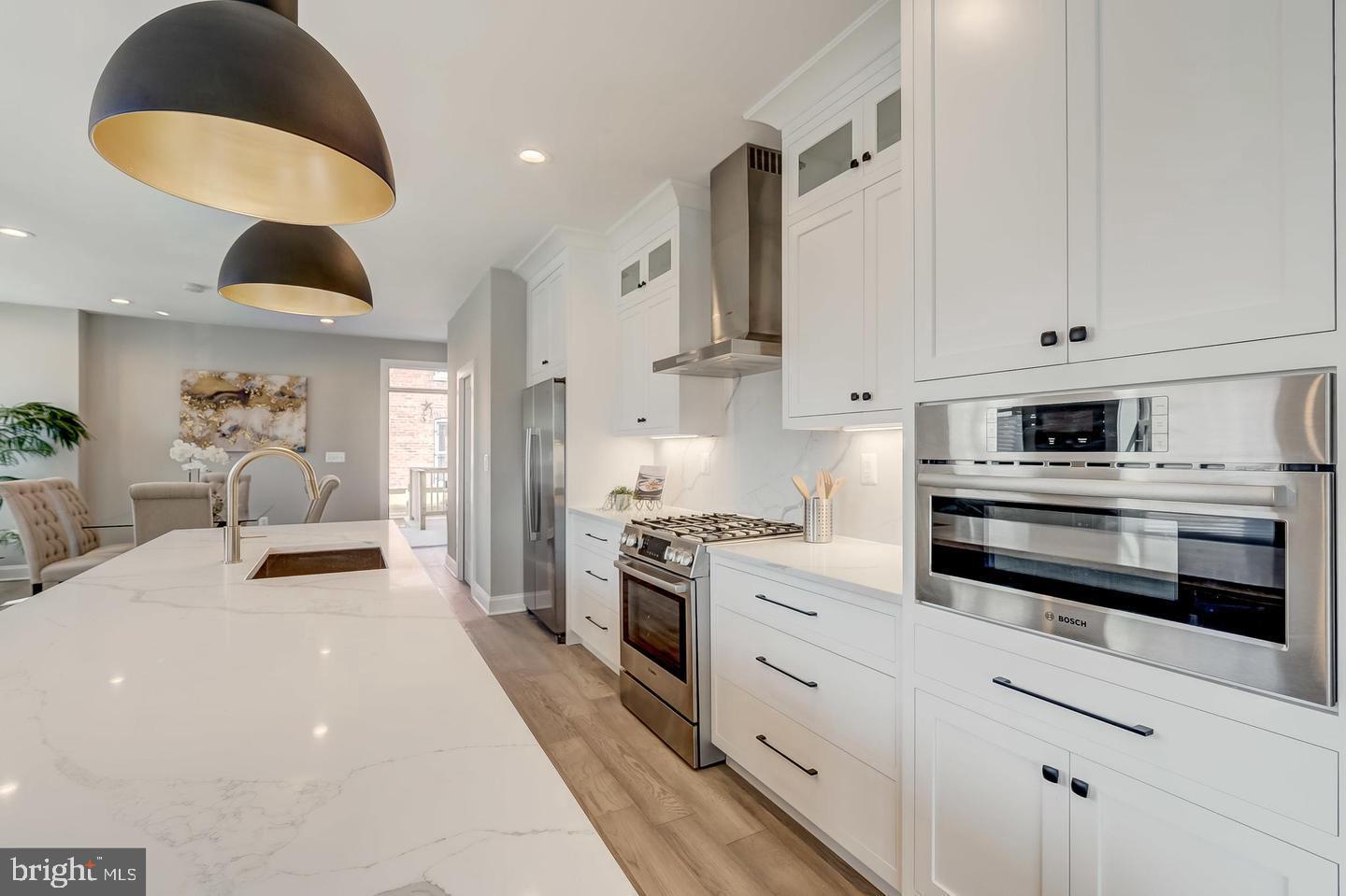 319 R Street Northwest Washington, DC 20001 - Photo 7 of 33 a kitchen with stainless steel appliances kitchen island granite countertop a stove a sink and white cabinets with wooden floor