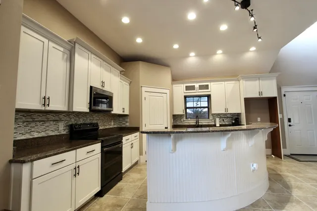 a kitchen with stainless steel appliances a sink stove and microwave