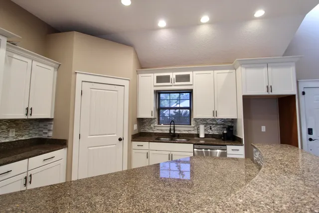 a kitchen with stainless steel appliances granite countertop a stove a sink and a refrigerator