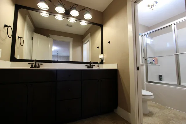 a bathroom with a sink a light fixture and a glass door