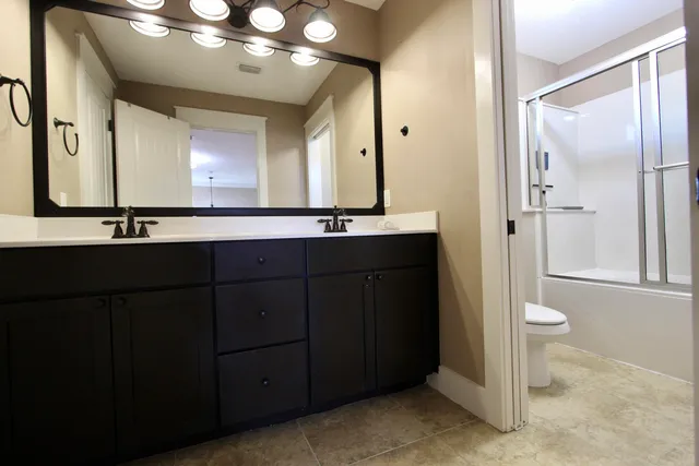 a bathroom with a double vanity sink and a mirror