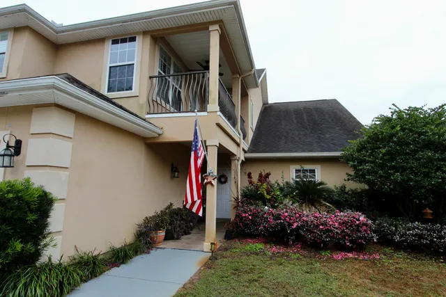a front view of house and yard with beautiful flowers