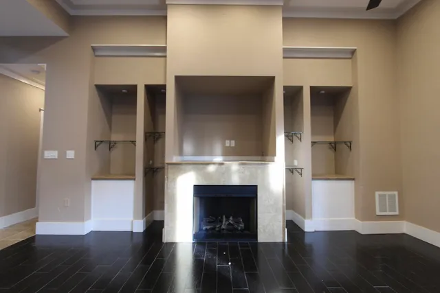 a living room with wooden floor and a fireplace