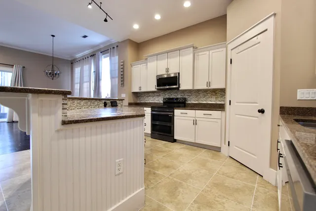 a kitchen with stainless steel appliances granite countertop a stove a sink a refrigerator a microwave and cabinets