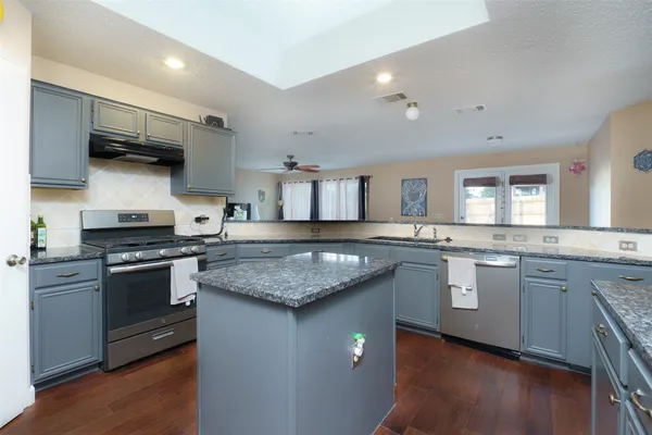a kitchen with stainless steel appliances granite countertop a stove sink and cabinets