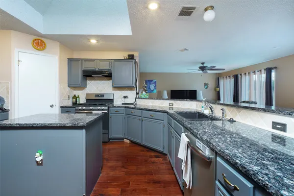 a kitchen with granite countertop stainless steel appliances and sink