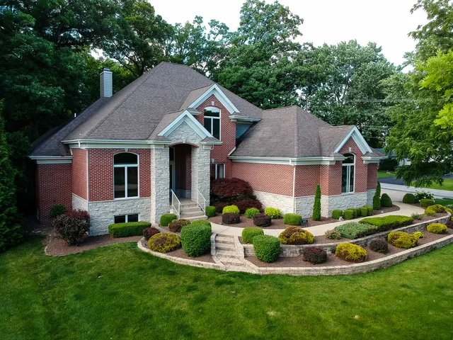 a aerial view of a house with table and chairs under an umbrella