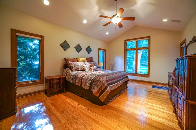 a bedroom with a bed chandelier and a window