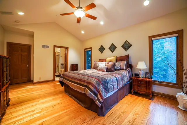 a spacious bedroom with a large bed and a chandelier