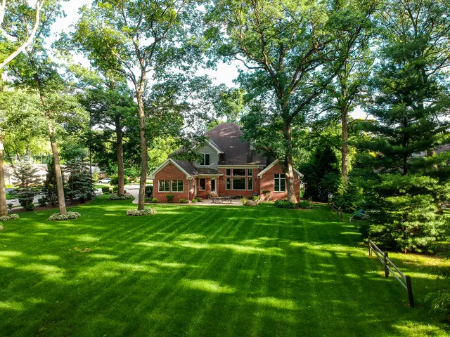 a front view of a house with a yard and trees