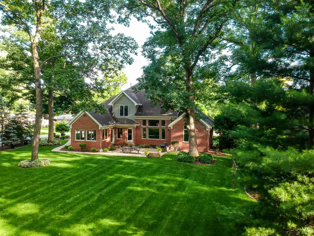 a front view of a house with a yard and trees
