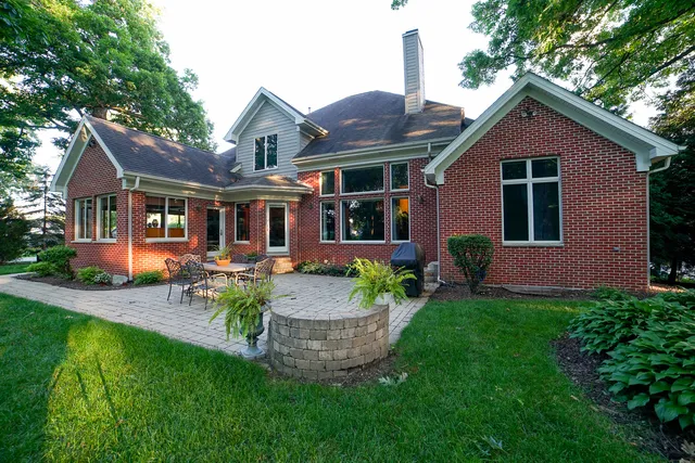 a view of a house with a yard and lawn chairs