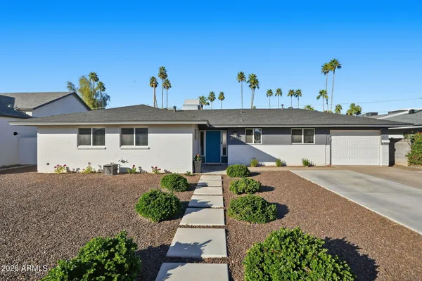 a front view of a house with a garden and plants