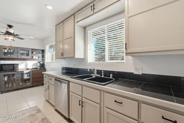 a kitchen with granite countertop a sink a stove and cabinets