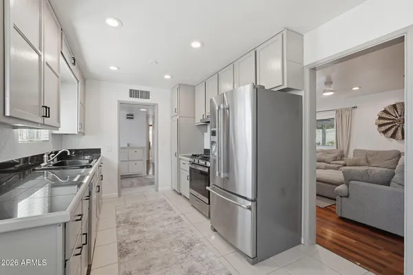 a kitchen with stainless steel appliances granite countertop a refrigerator a stove and a sink