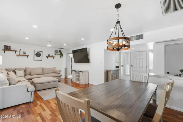 a living room with furniture a flat screen tv and kitchen view