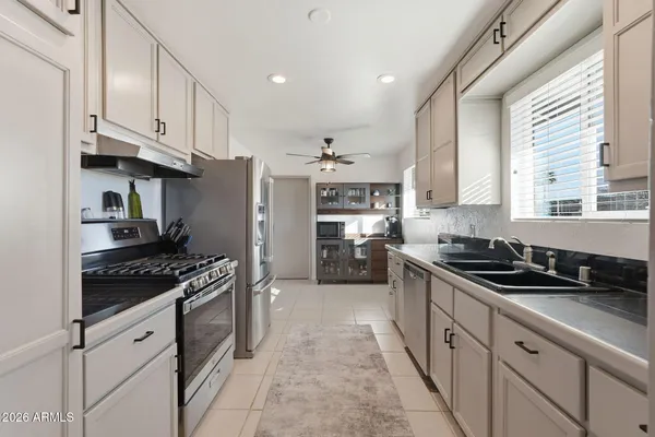 a kitchen with stainless steel appliances granite countertop a stove a sink and a refrigerator