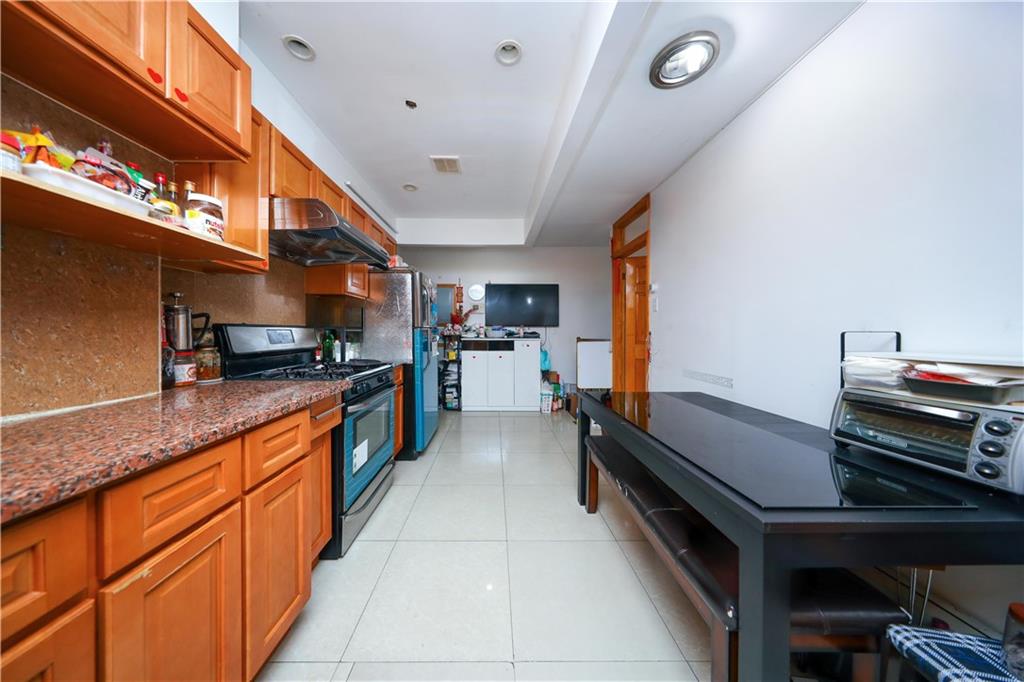 5418 3rd Avenue, Unit 1A Brooklyn, NY 11220 - Photo 4 of 12 a kitchen with stainless steel appliances granite countertop a sink and stove