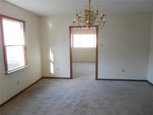 an empty room with a windows and chandelier