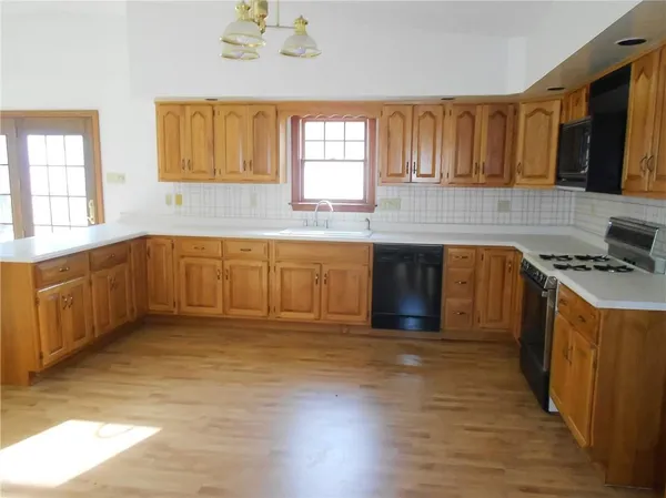 a kitchen with stainless steel appliances granite countertop a stove a sink dishwasher and a microwave oven with wooden floor
