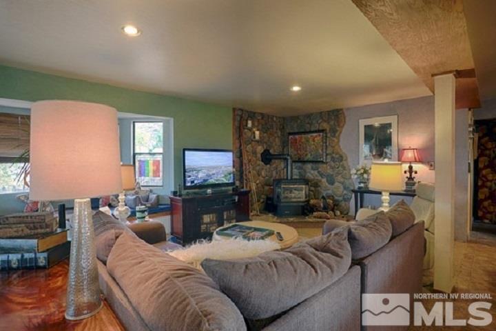 255 Curnow Canyon Road Reno, NV 89510 - Photo 4 of 25 a living room with furniture a flat screen tv and a fireplace