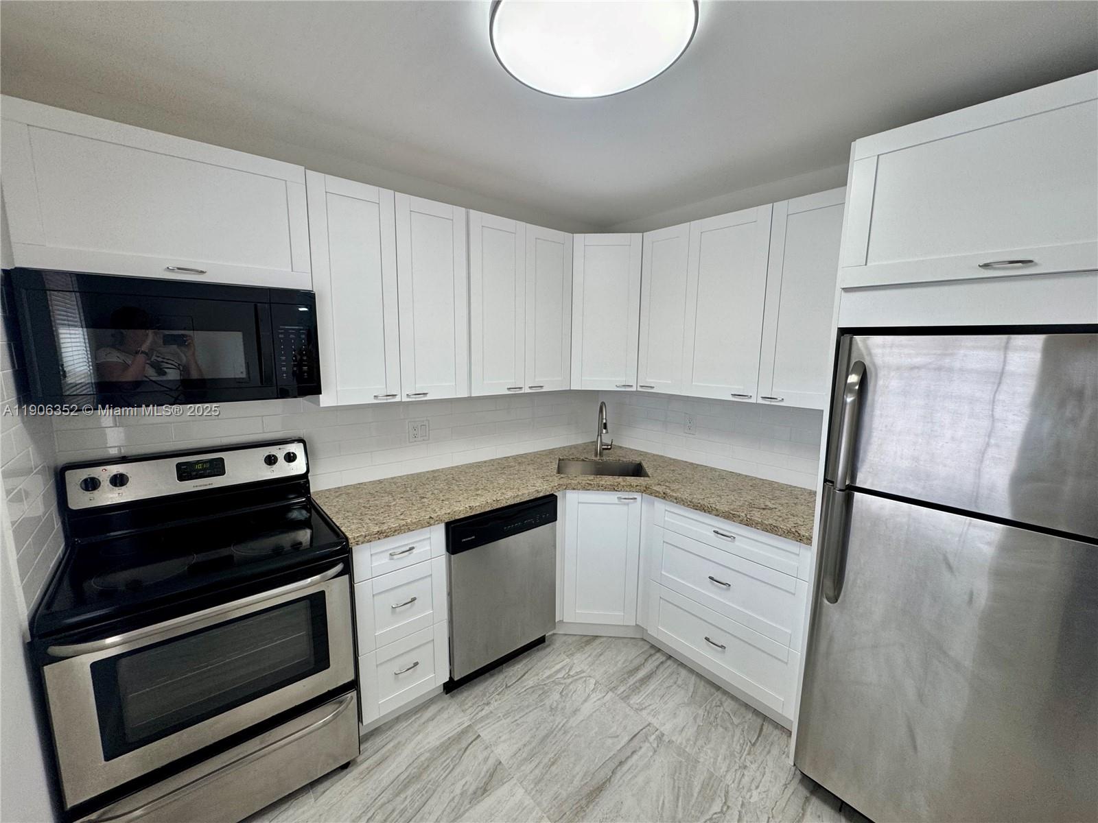 7205 Northwest 5th Court, Unit 202 Margate, FL 33063 - Photo 1 of 15 a kitchen with a sink stove and microwave