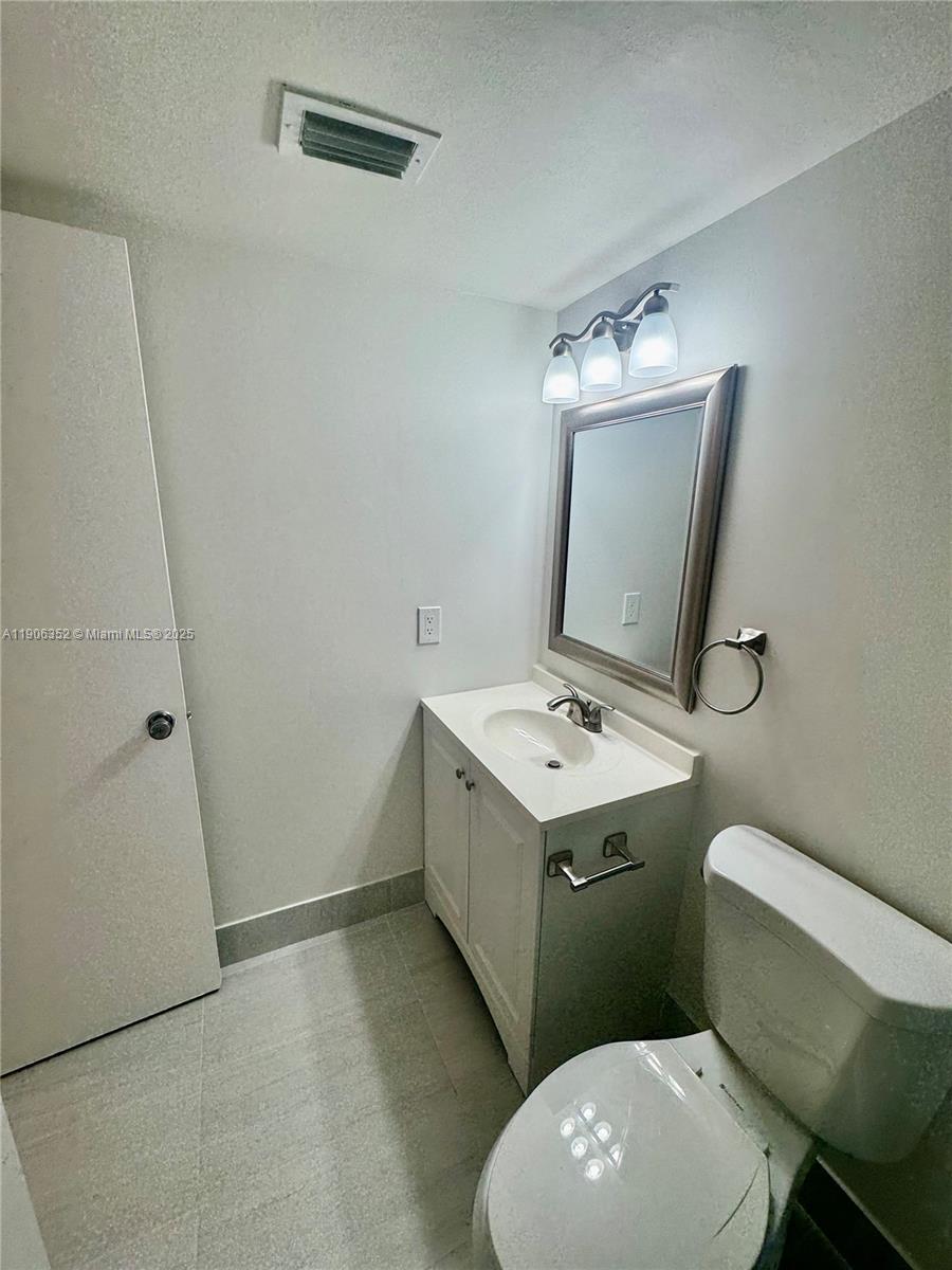 7205 Northwest 5th Court, Unit 202 Margate, FL 33063 - Photo 9 of 15 a bathroom with a toilet sink and mirror