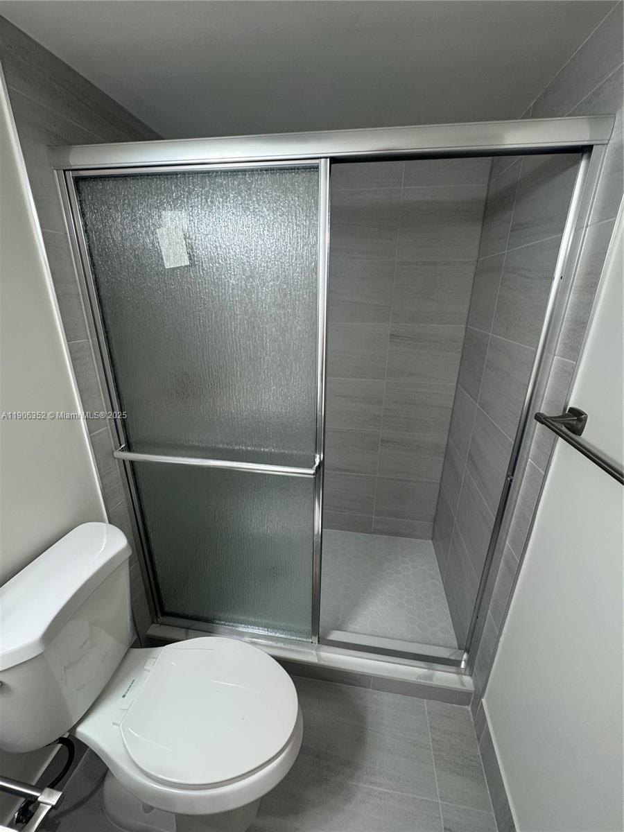 7205 Northwest 5th Court, Unit 202 Margate, FL 33063 - Photo 10 of 15 a white toilet sitting next to a shower