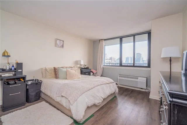 a bedroom with a bed and a dresser next to a window