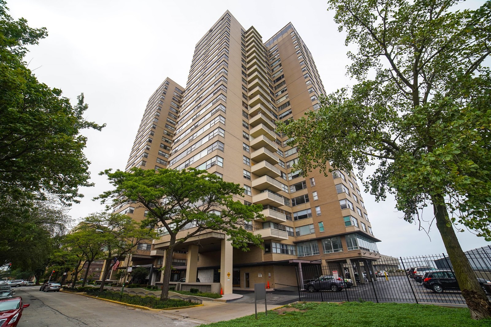 6301 North Sheridan Road, Unit 22N Chicago, IL 60660 - Photo 1 of 9 a front view of a building with trees
