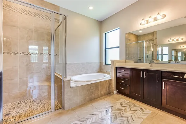 a spacious bathroom with a tub sink shower and mirror