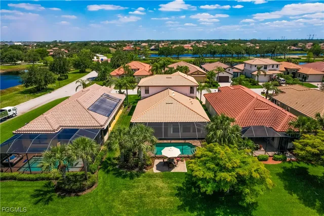 an aerial view of residential houses with outdoor space and a lake view