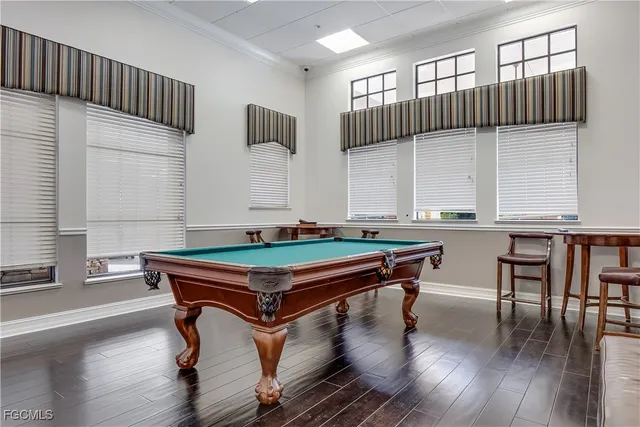 a room with wooden floor pool table table soccer and windows