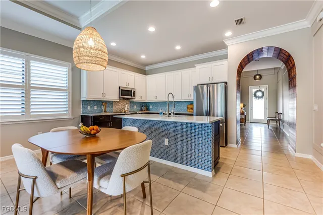 a kitchen with stainless steel appliances granite countertop a sink a stove and a dining table with kitchen island