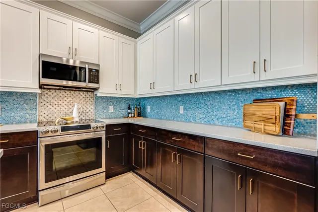 a kitchen with stainless steel appliances granite countertop white cabinets and a stove top oven