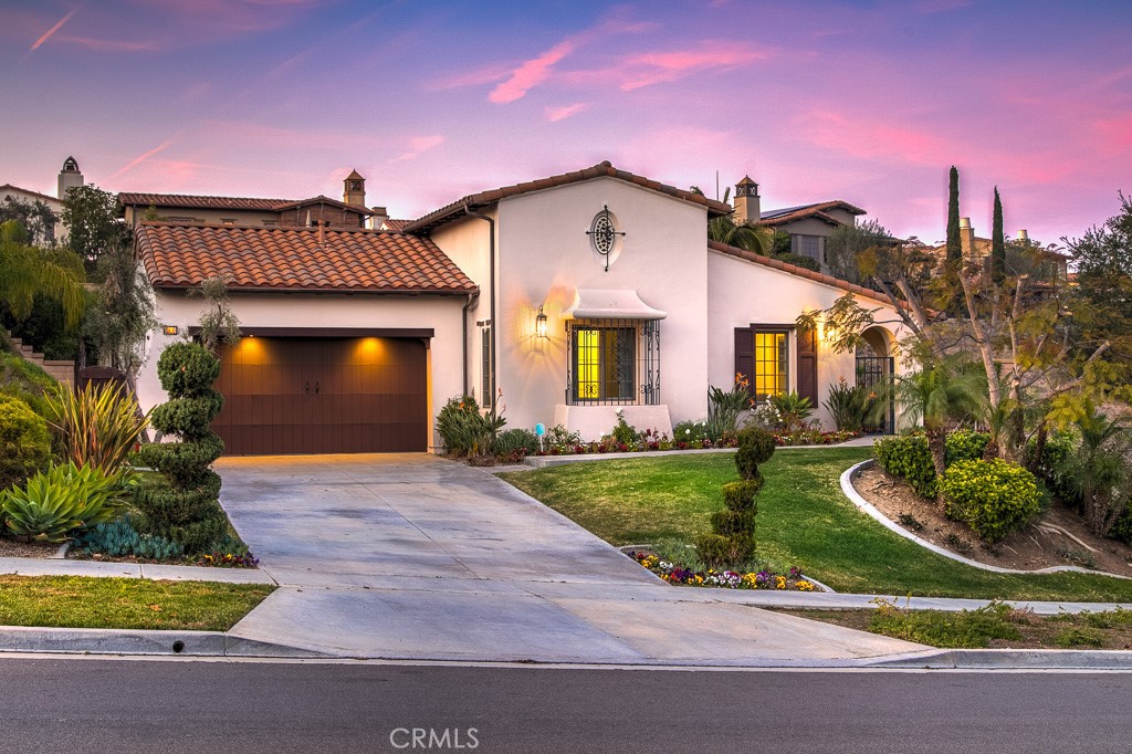 a front view of a house with a yard and potted plants