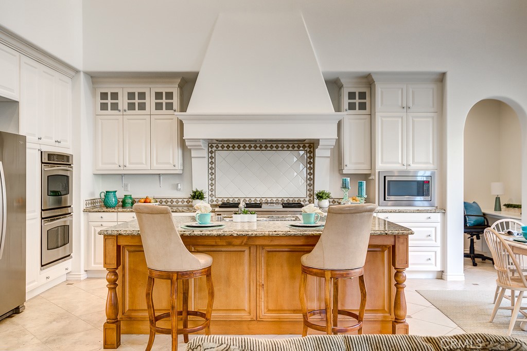 501 Luminous Irvine, CA 92603 - Photo 15 of 53 a kitchen with stainless steel appliances kitchen island granite countertop a table and chairs in it