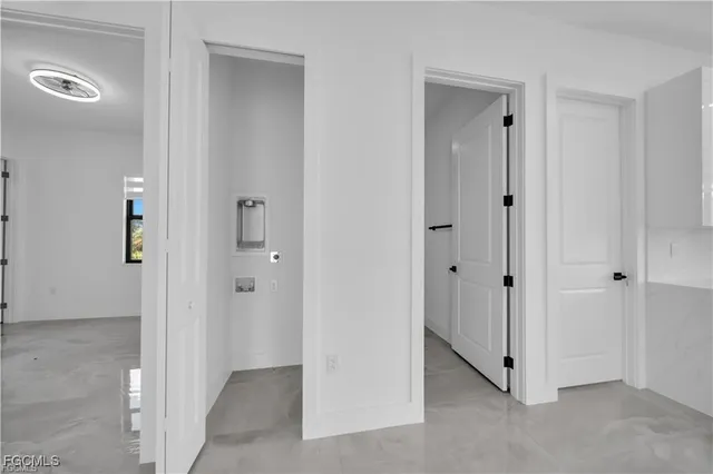 a view of an empty room with closet and mirror