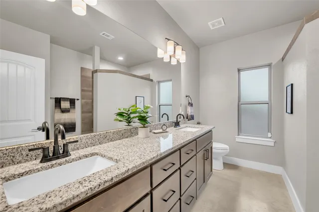 a bathroom with a granite countertop sink double and mirror