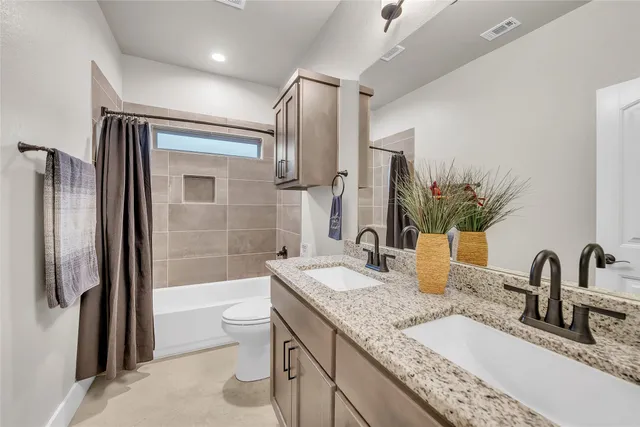 a bathroom with a granite countertop sink a toilet and shower