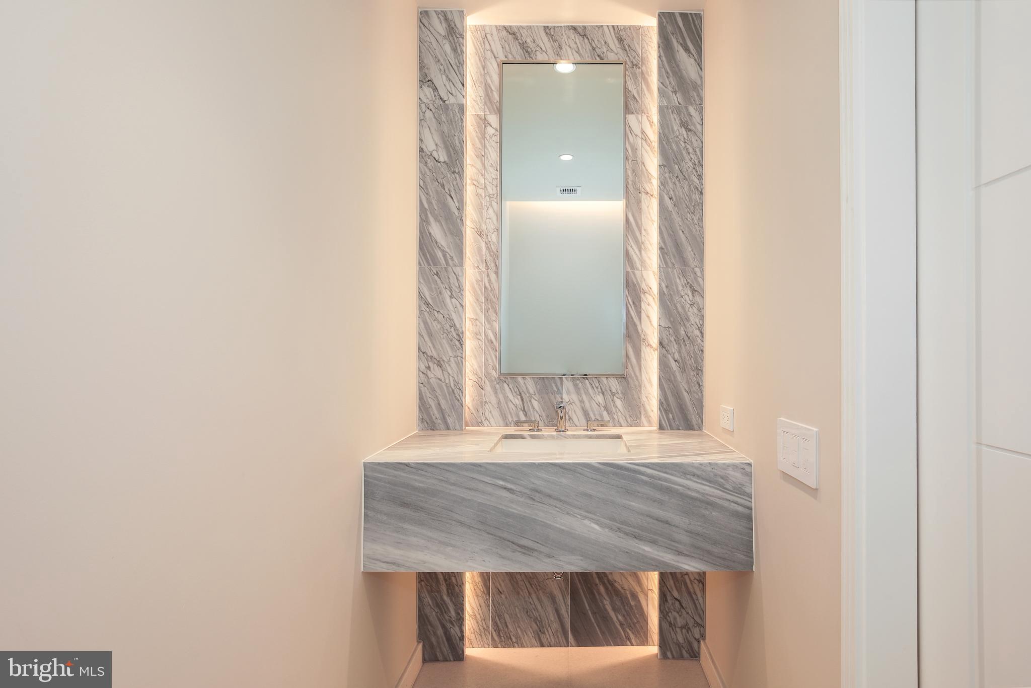601 Wharf Street Southwest, Unit 905 Washington, DC 20024 - Photo 18 of 28 a bathroom with a granite countertop sink and a mirror