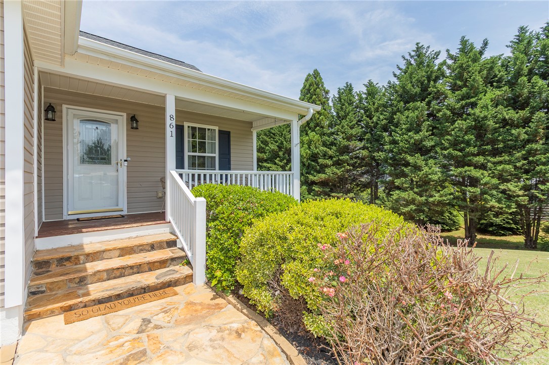 861 North Old Pendleton Road Liberty, SC 29657 - Photo 4 of 45 A welcoming front porch features stone steps and mature landscaping, leading to a charming entry.