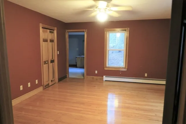a view of an empty room with window and bathroom