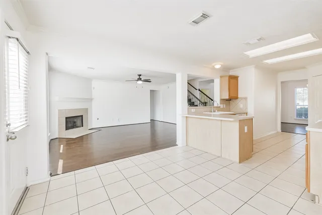 an empty room with wooden floor fireplace and windows