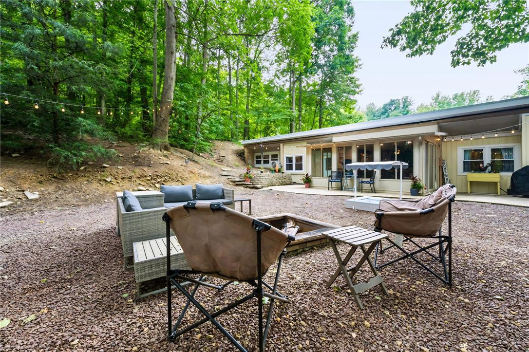 74 Turkey Road Kempton, PA 19529 - Photo 3 of 65 MAIN HOME - An inviting backyard oasis offers a built-in fire pit and string lights, perfect for evening gatherings.