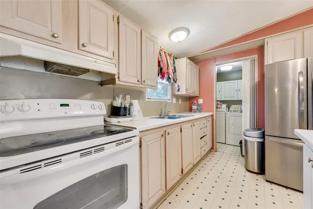 a kitchen with granite countertop white cabinets and stainless steel appliances