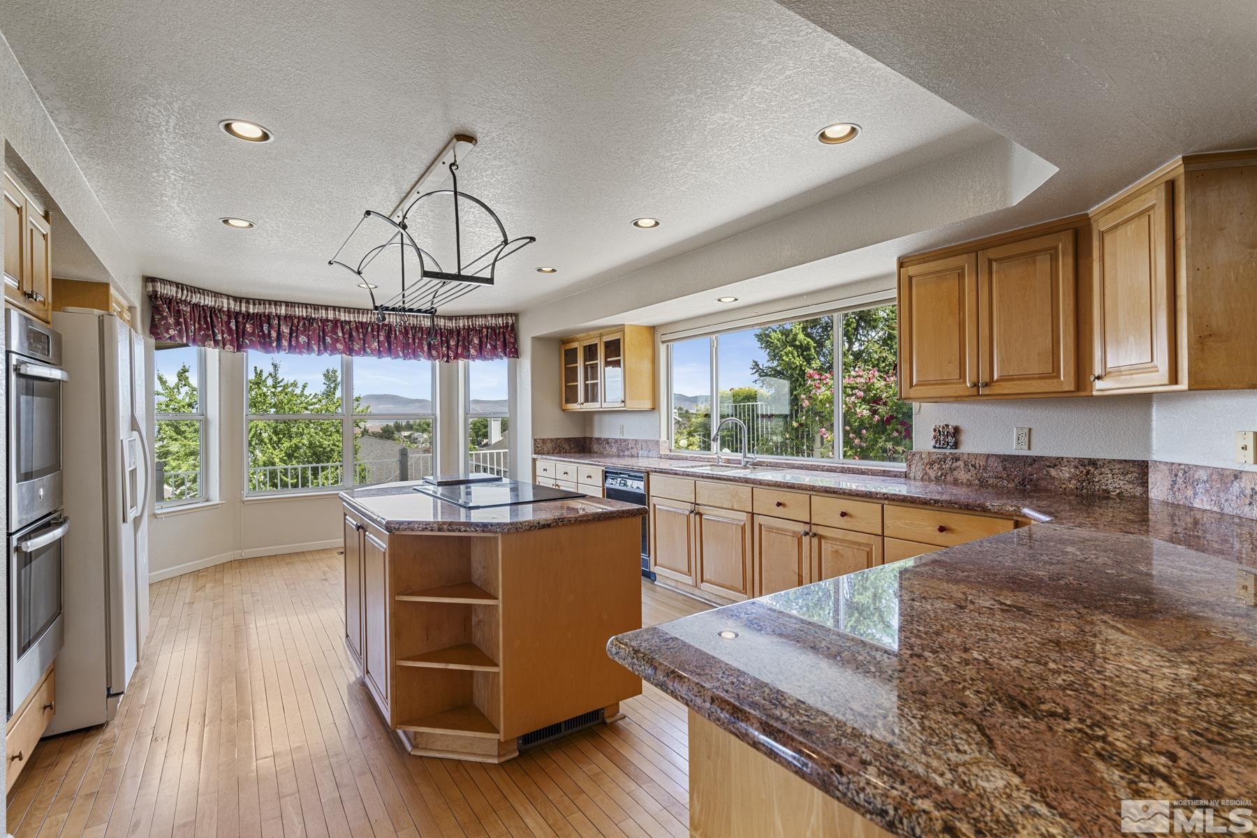 6172 Squires Lane Reno, NV 89519 - Photo 13 of 40 a kitchen with stainless steel appliances granite countertop wooden floors and sink
