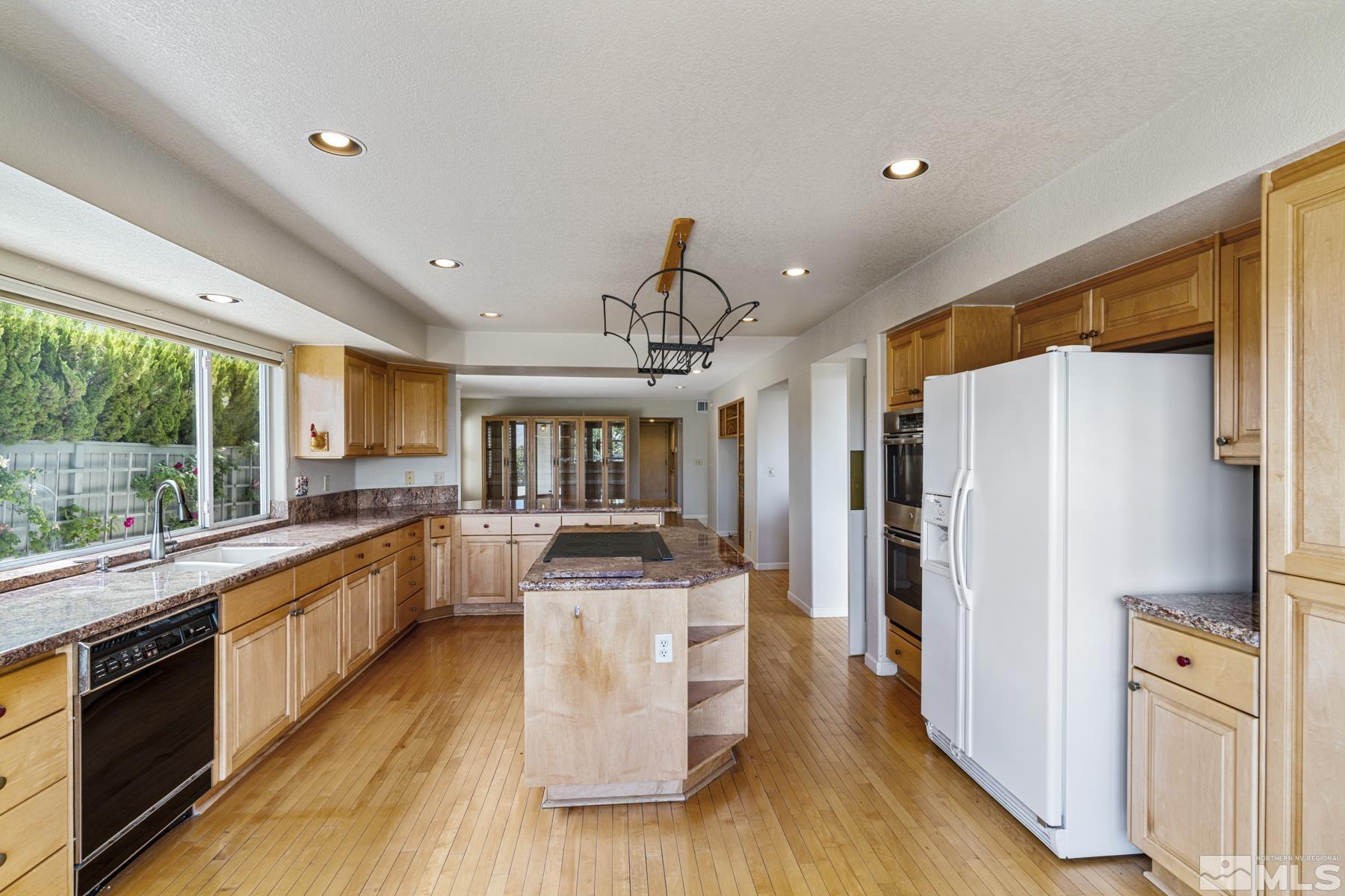 6172 Squires Lane Reno, NV 89519 - Photo 16 of 40 a kitchen with stainless steel appliances a refrigerator a stove top oven and a kitchen island